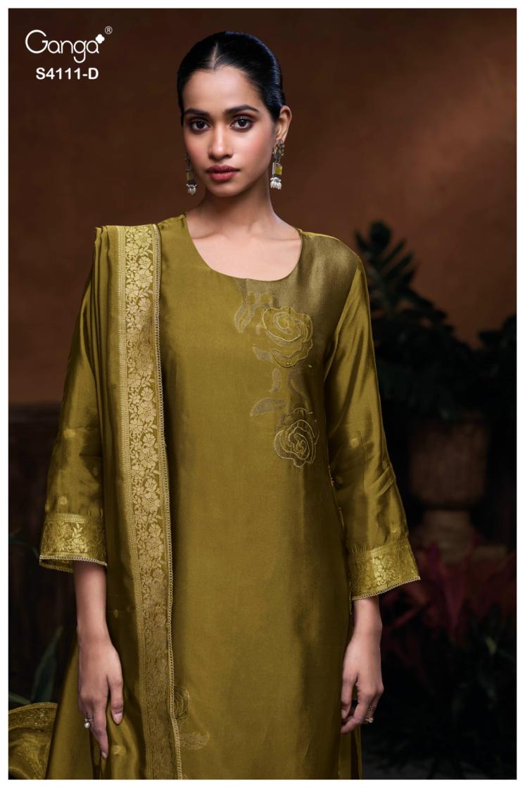 Woman wearing a green traditional outfit with embroidery, brand 'Ganga' visible